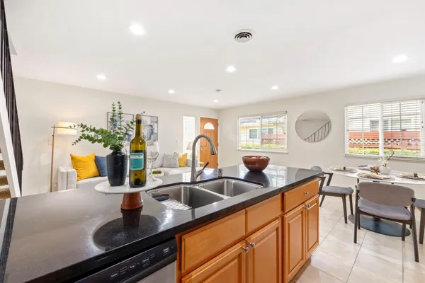 a kitchen with granite countertop a sink and white cabinets
