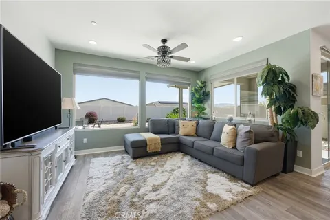 a living room with furniture flat screen tv and a large window