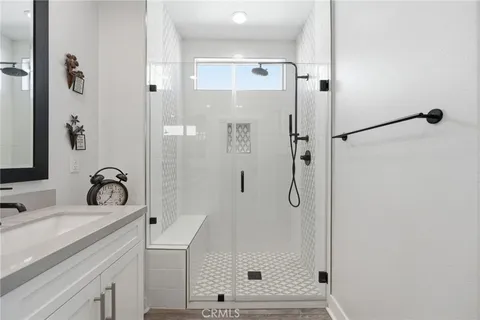 a bathroom with a granite countertop shower sink and mirror