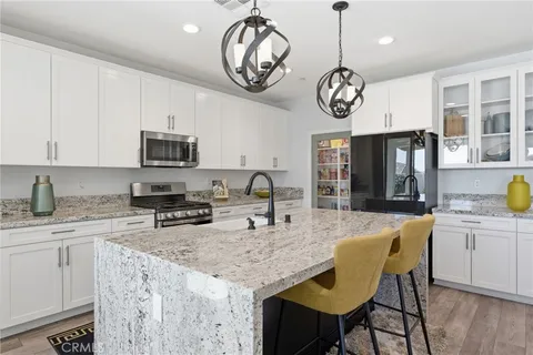 a view of kitchen with sink microwave refrigerator dining table and chairs