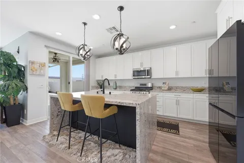 a kitchen with kitchen island granite countertop a sink a center island and cabinets