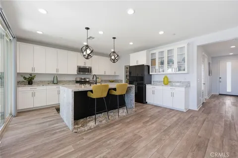 a kitchen with kitchen island granite countertop a sink cabinets and wooden floor
