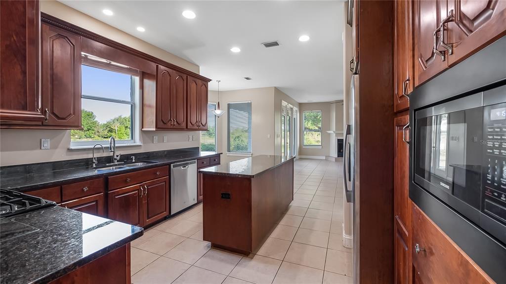 10651 Arrowtree Boulevard Clermont, FL 34715 - Photo 18 of 51 a kitchen with stainless steel appliances granite countertop wooden cabinets a sink and a oven