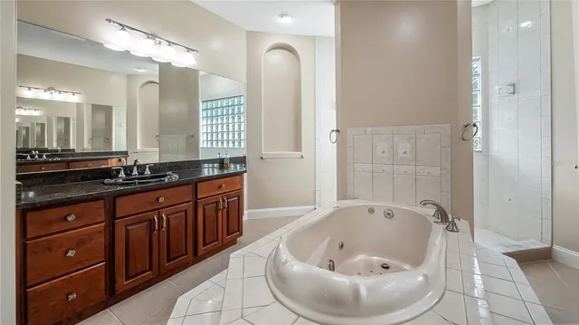 a bathroom with a granite countertop sink and a mirror a bathtub