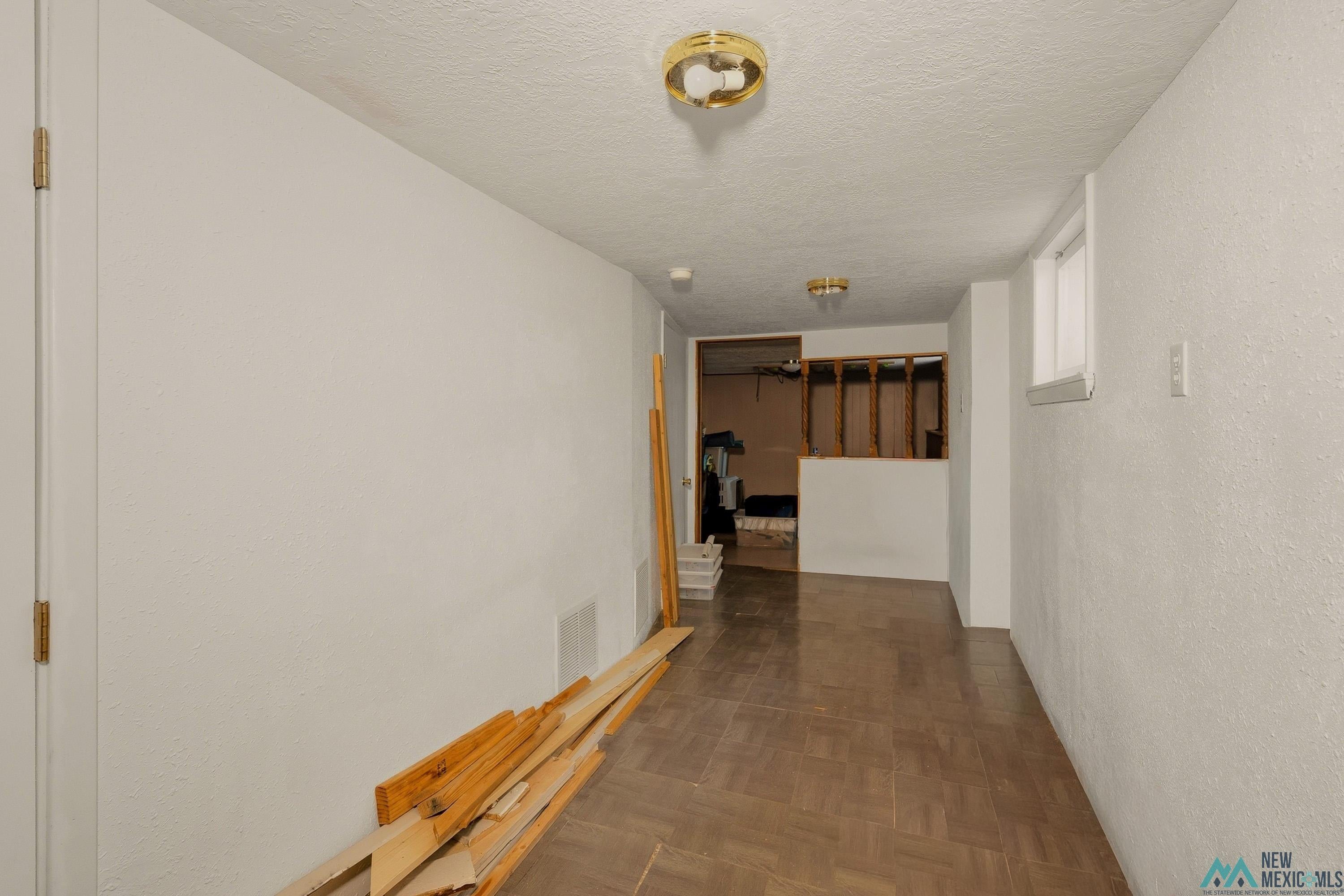 1026 South 5th Street Raton, NM 87740 - Photo 21 of 33 Finished basement area featuring wood-look flooring and a small window