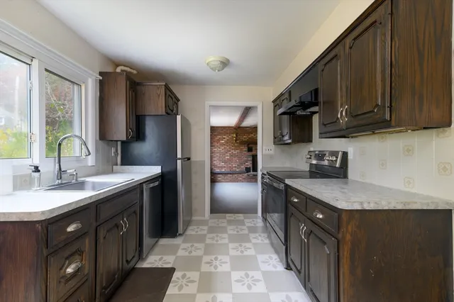 a kitchen with stainless steel appliances granite countertop a sink stove and refrigerator