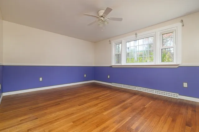 an empty room with a window and a ceiling fan
