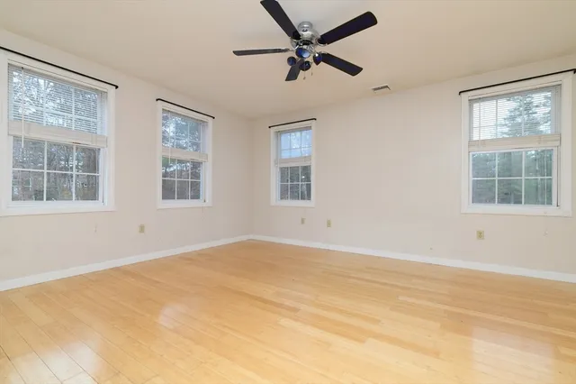 a view of an empty room with a window and a ceiling fan