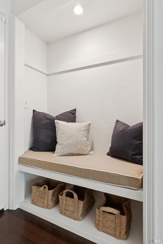 a bedroom with a bed table chair and a two windows