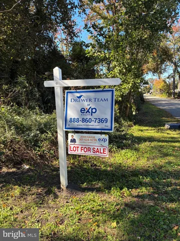 a sign broad in front of the red and white house