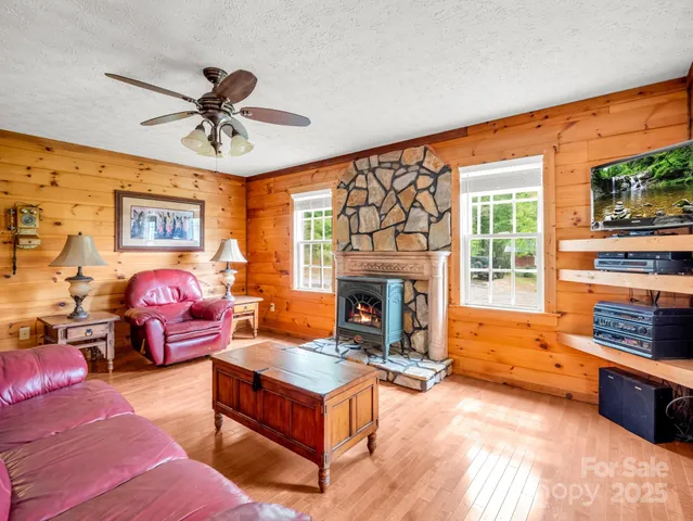 a living room with furniture a fireplace and a large window