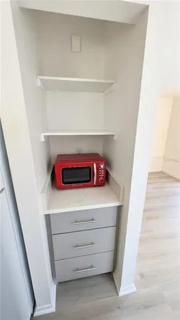 a view of storage and utility room with wooden floor