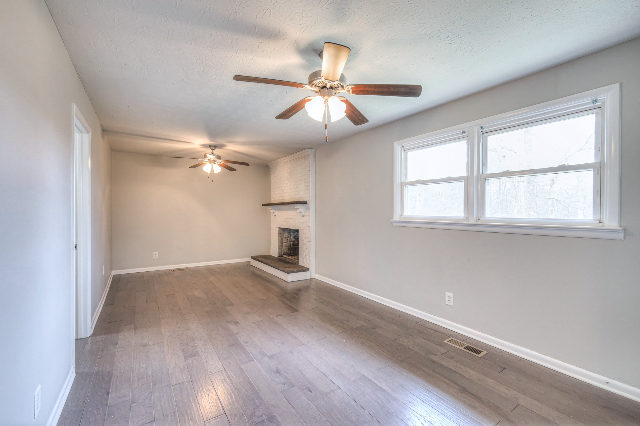 320 Ramsey Road Lebanon, TN 37087 - Photo 12 of 28 an empty room with wooden floor fan and windows