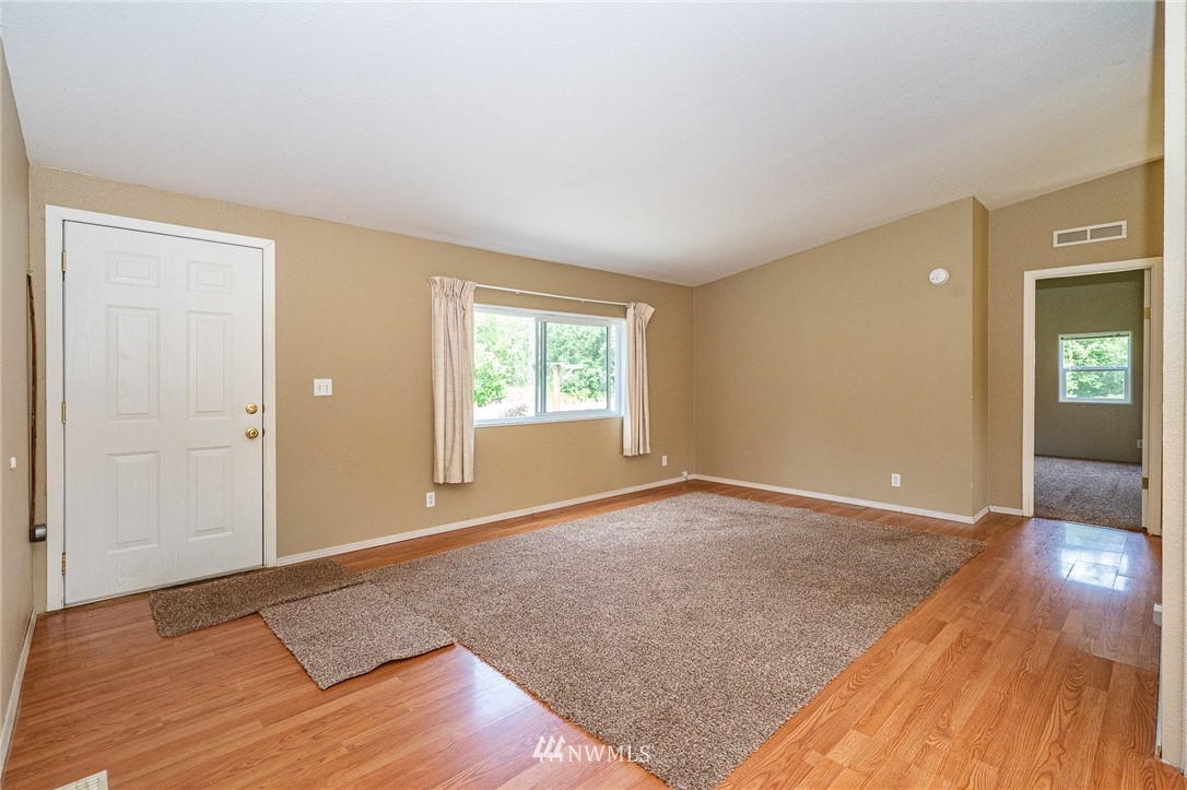 144 Hershel Road Chehalis, WA 98532 - Photo 3 of 40 an empty room with wooden floor and windows