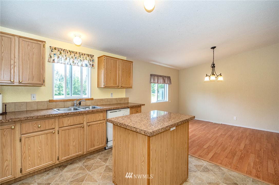 144 Hershel Road Chehalis, WA 98532 - Photo 9 of 40 a kitchen with granite countertop sink stove and white cabinets with wooden floor