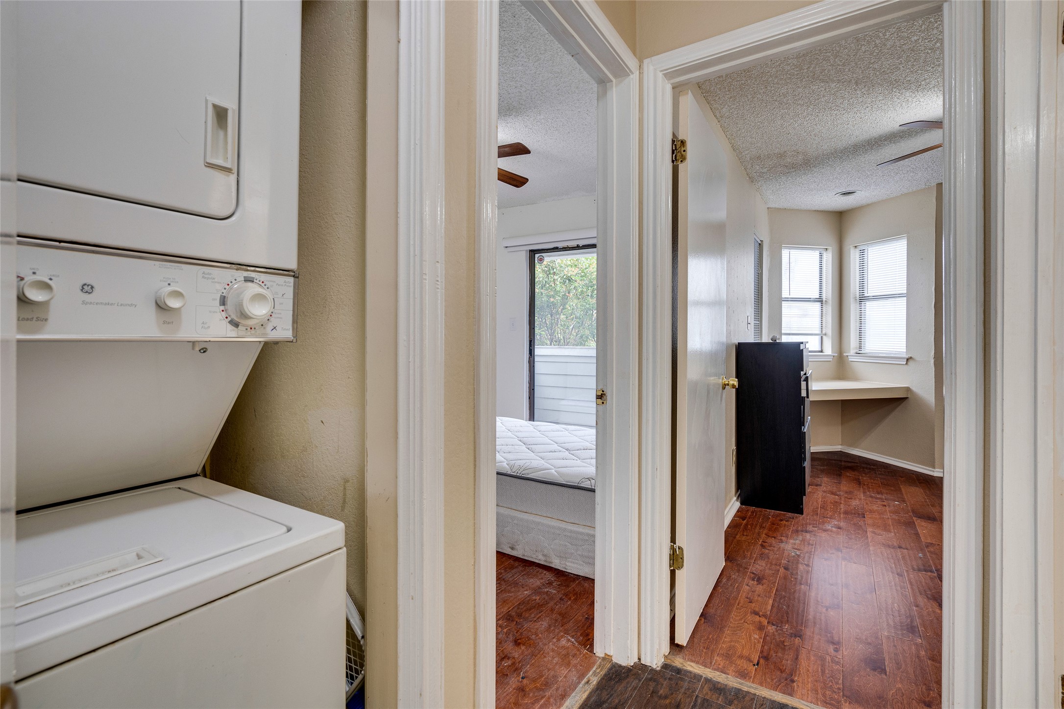 1808 Rio Grande Street, Unit 6 Austin, TX 78701 - Photo 14 of 29 Laundry area with ceiling fan, stacked washer / dryer, dark wood-style flooring, and a textured ceiling