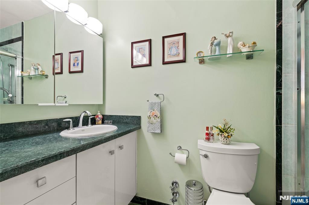 280 Prospect, Unit 9H Hackensack, NJ 07601 - Photo 11 of 37 a bathroom with a granite countertop sink and a mirror