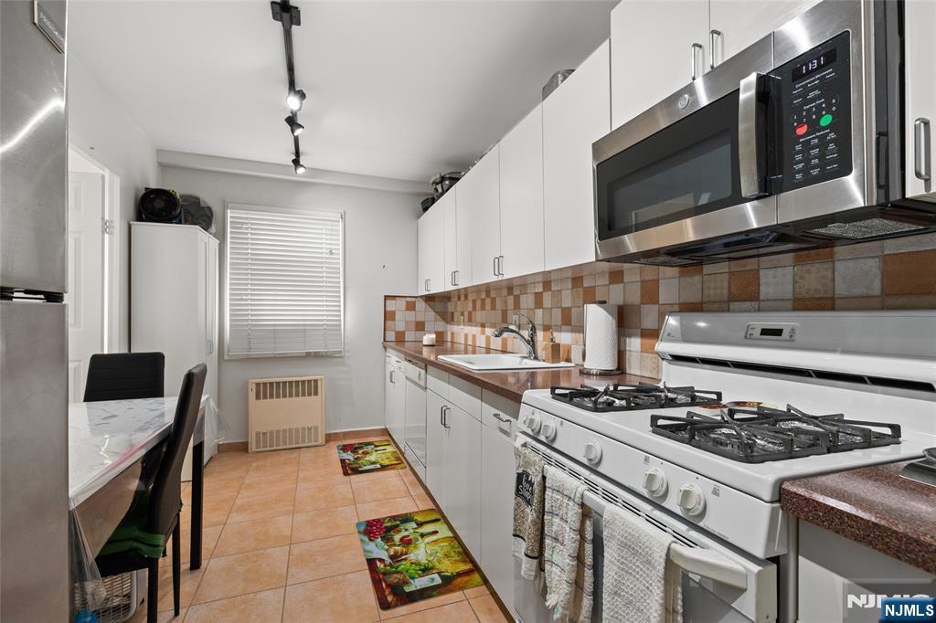 280 Prospect, Unit 9H Hackensack, NJ 07601 - Photo 3 of 37 a kitchen with stainless steel appliances granite countertop a stove and a microwave