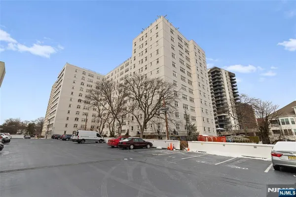 a view of a buildings with cars parked in front of it