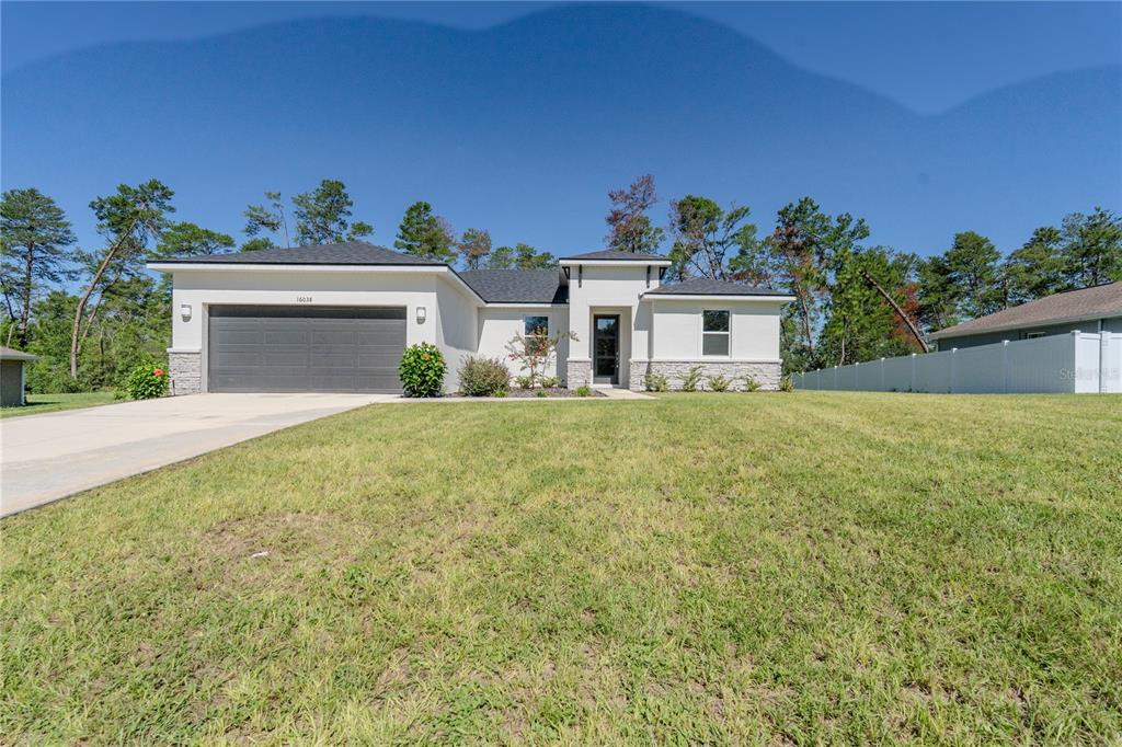 a front view of a house with a yard and garage