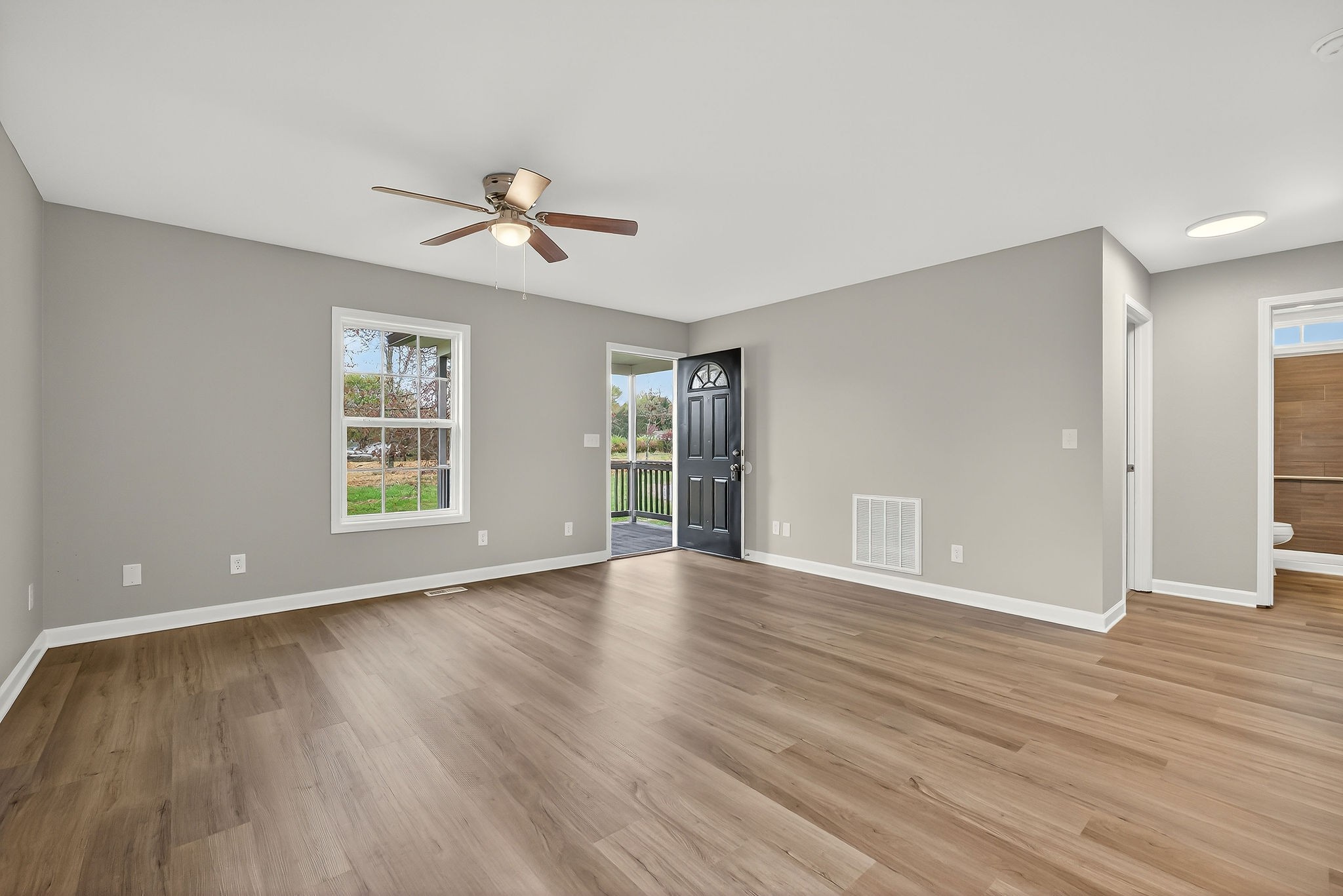 1193 Ashburn Road Monterey, TN 38574 - Photo 4 of 28 an empty room with wooden floor ceiling fan and windows