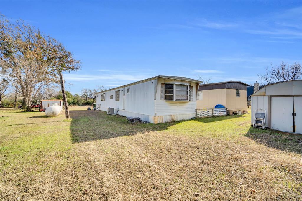 3107 Russell Road Arlington, TX 76001 - Photo 21 of 37 New Water Well Shed, Propane Tank, Mobile 2, Mobile 1 and Storage Shed (left to right)
