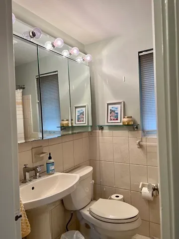 a bathroom with a sink a toilet and mirror
