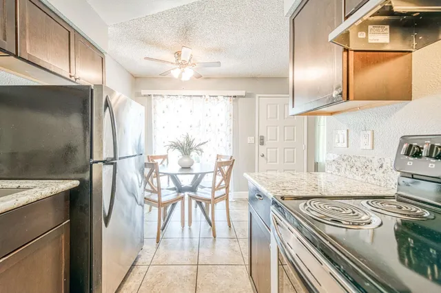 a kitchen with stainless steel appliances granite countertop a stove a refrigerator and a dining table
