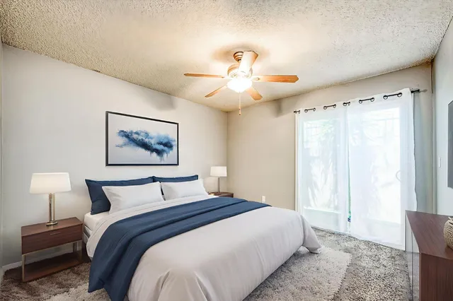 a bedroom with a large bed and a chandelier
