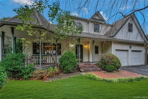 a view of a house with brick walls and a yard with plants