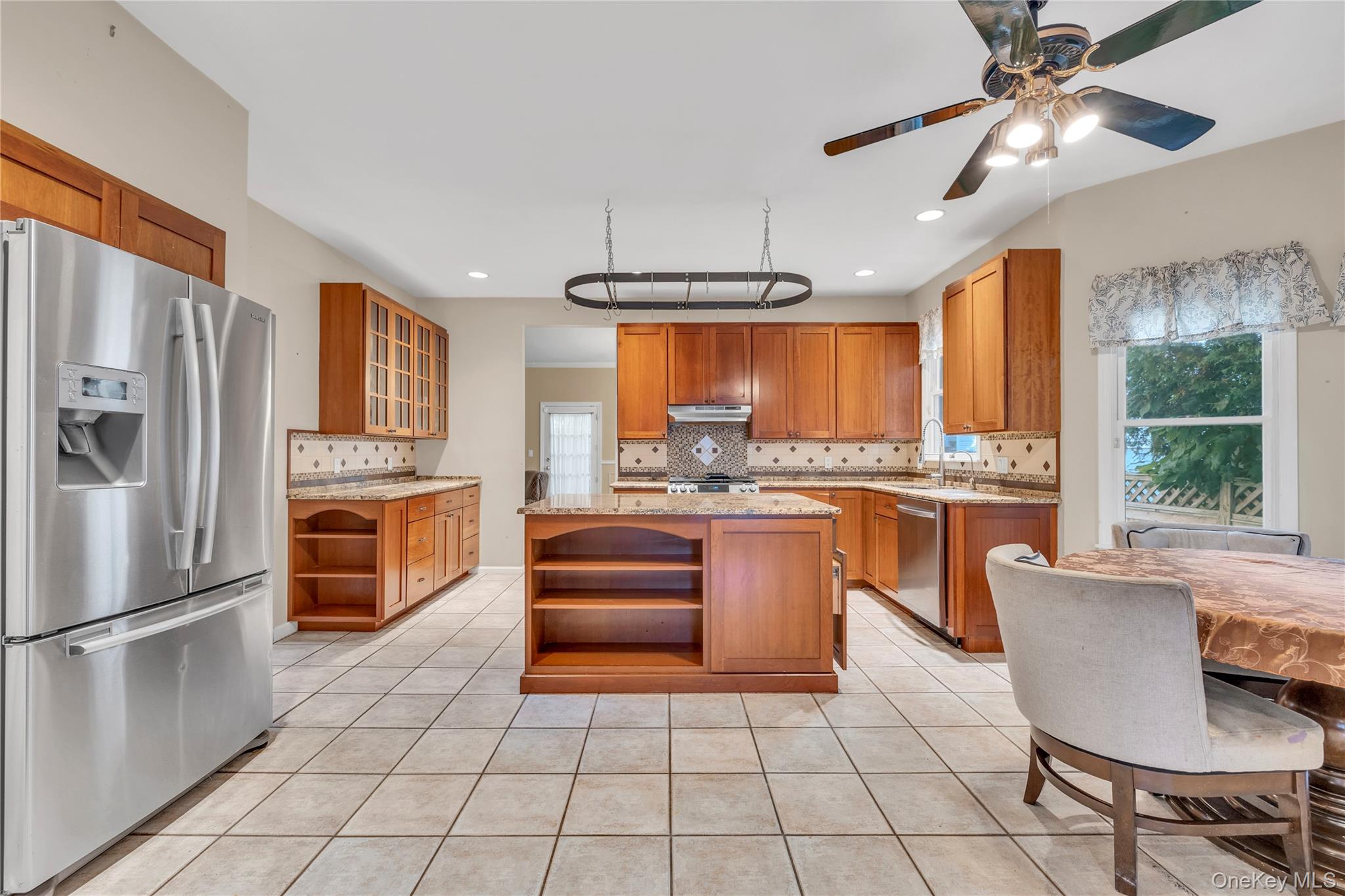 124 Fleets Cove Road Huntington, NY 11743 - Photo 11 of 35 a kitchen with stainless steel appliances a refrigerator a stove a sink and chairs