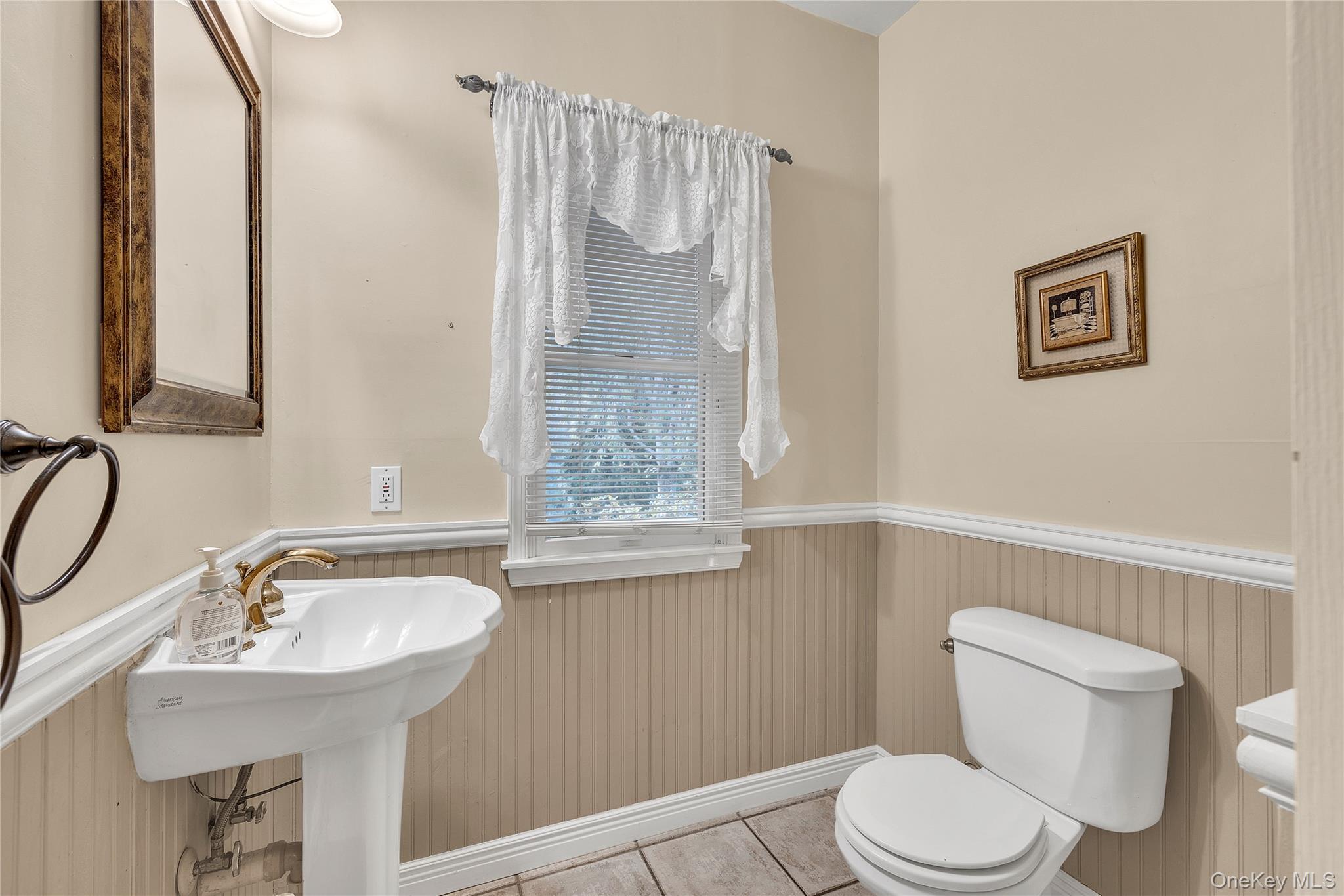 124 Fleets Cove Road Huntington, NY 11743 - Photo 16 of 35 a bathroom with a sink a toilet and a mirror