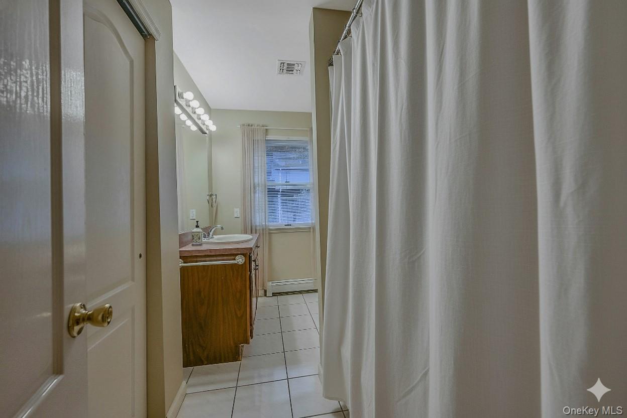 124 Fleets Cove Road Huntington, NY 11743 - Photo 25 of 35 a bathroom with a granite countertop sink and a mirror