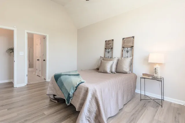 a bedroom with a bed and wooden floor