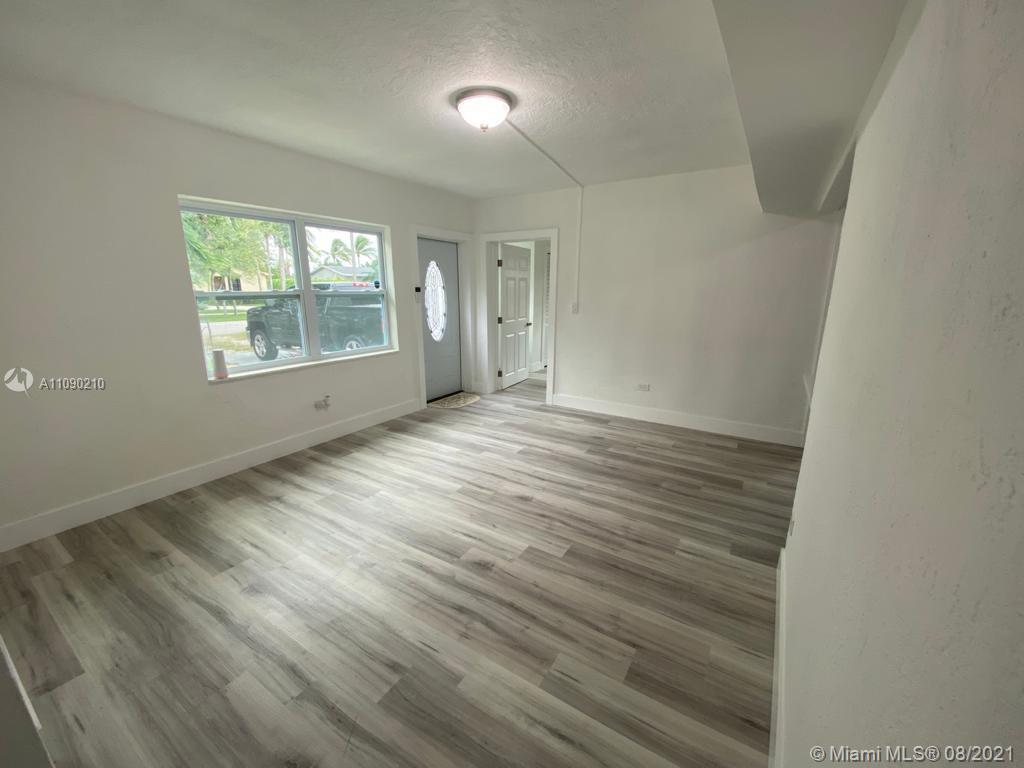 14801 Harding Lane Homestead, FL 33033 - Photo 8 of 26 an empty room with wooden floor and windows