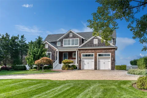 a front view of a house with a garden and plants
