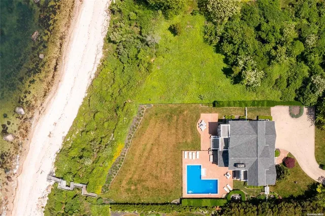 an aerial view of residential house with outdoor space and trees all around