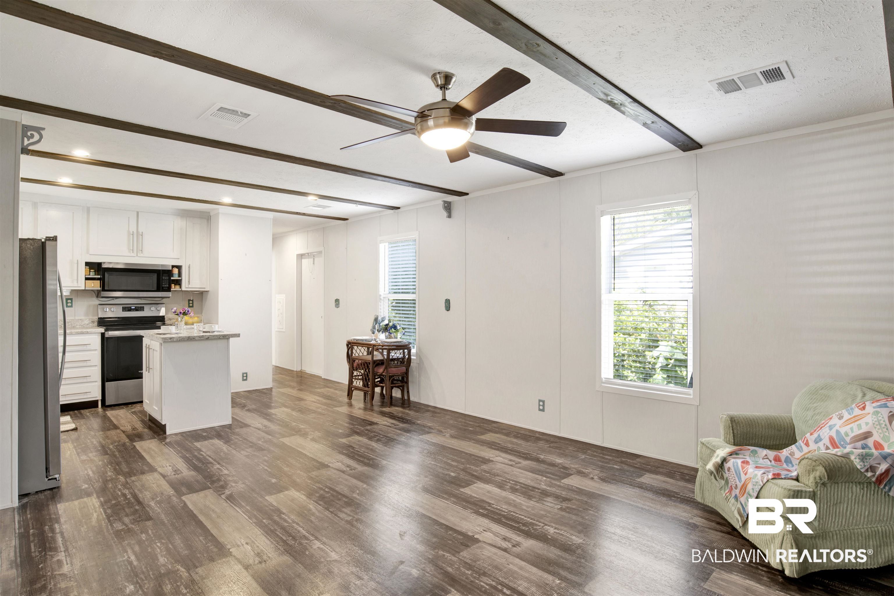 1411 Ridgewood Drive Lillian, AL 36549 - Photo 8 of 30 Kitchen with ceiling fan, white cabinets, a textured ceiling, appliances with stainless steel finishes, and dark hardwood / wood-style flooring
