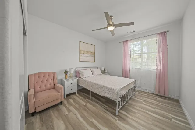 a bedroom with a large bed a chandelier and dresser