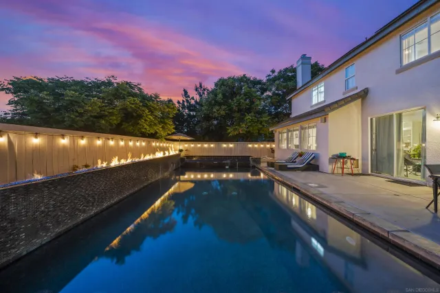 a view of a house with backyard and sitting area