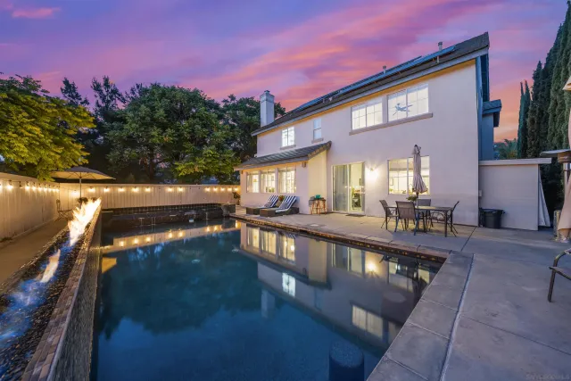 a view of a house with backyard and sitting area