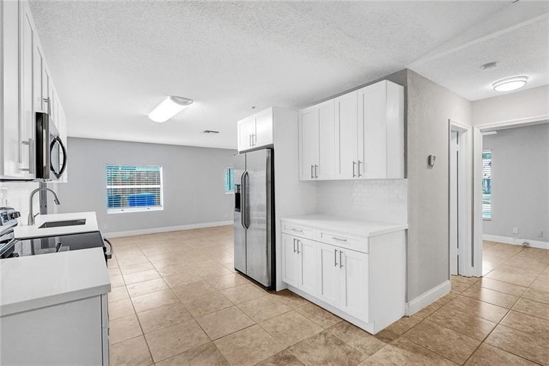 8221 Southwest 3rd Court Pompano Beach, FL 33068 - Photo 6 of 25 a kitchen with a stove a refrigerator and a sink