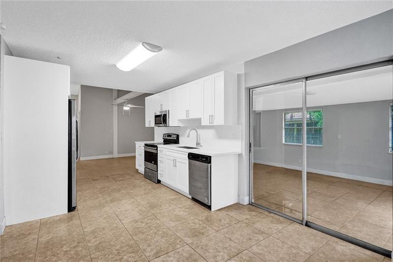 8221 Southwest 3rd Court Pompano Beach, FL 33068 - Photo 7 of 25 a kitchen with white cabinets and white appliances
