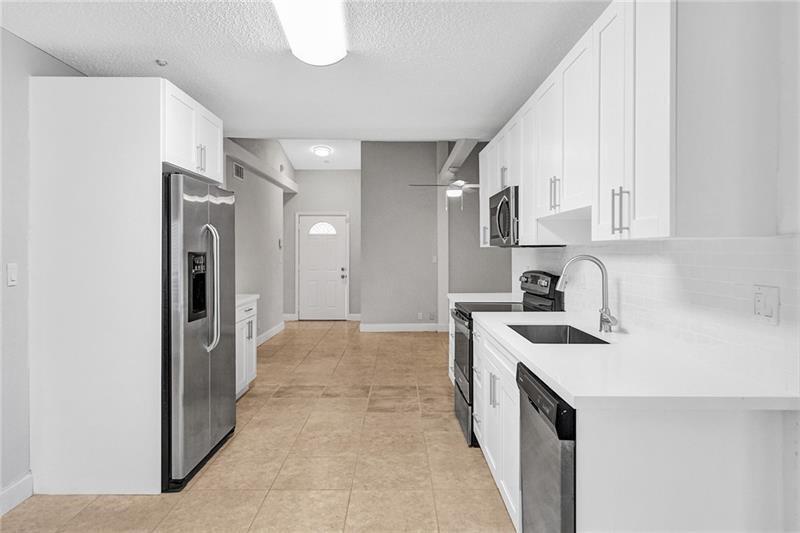 8221 Southwest 3rd Court Pompano Beach, FL 33068 - Photo 8 of 25 a view of a kitchen cabinets a sink and a stove in a kitchen