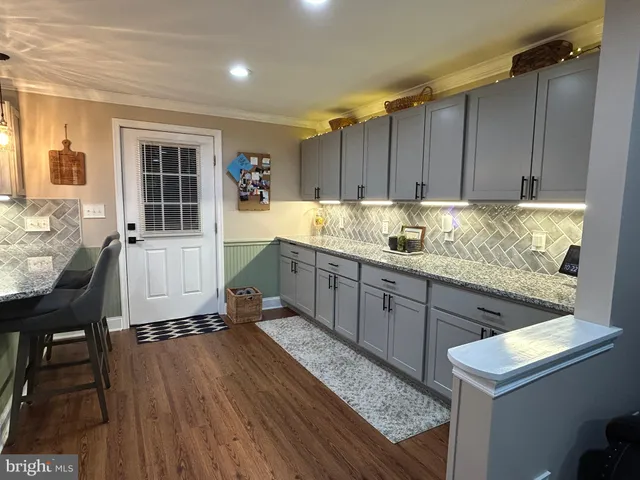 a kitchen with granite countertop a sink a counter space and wooden cabinets