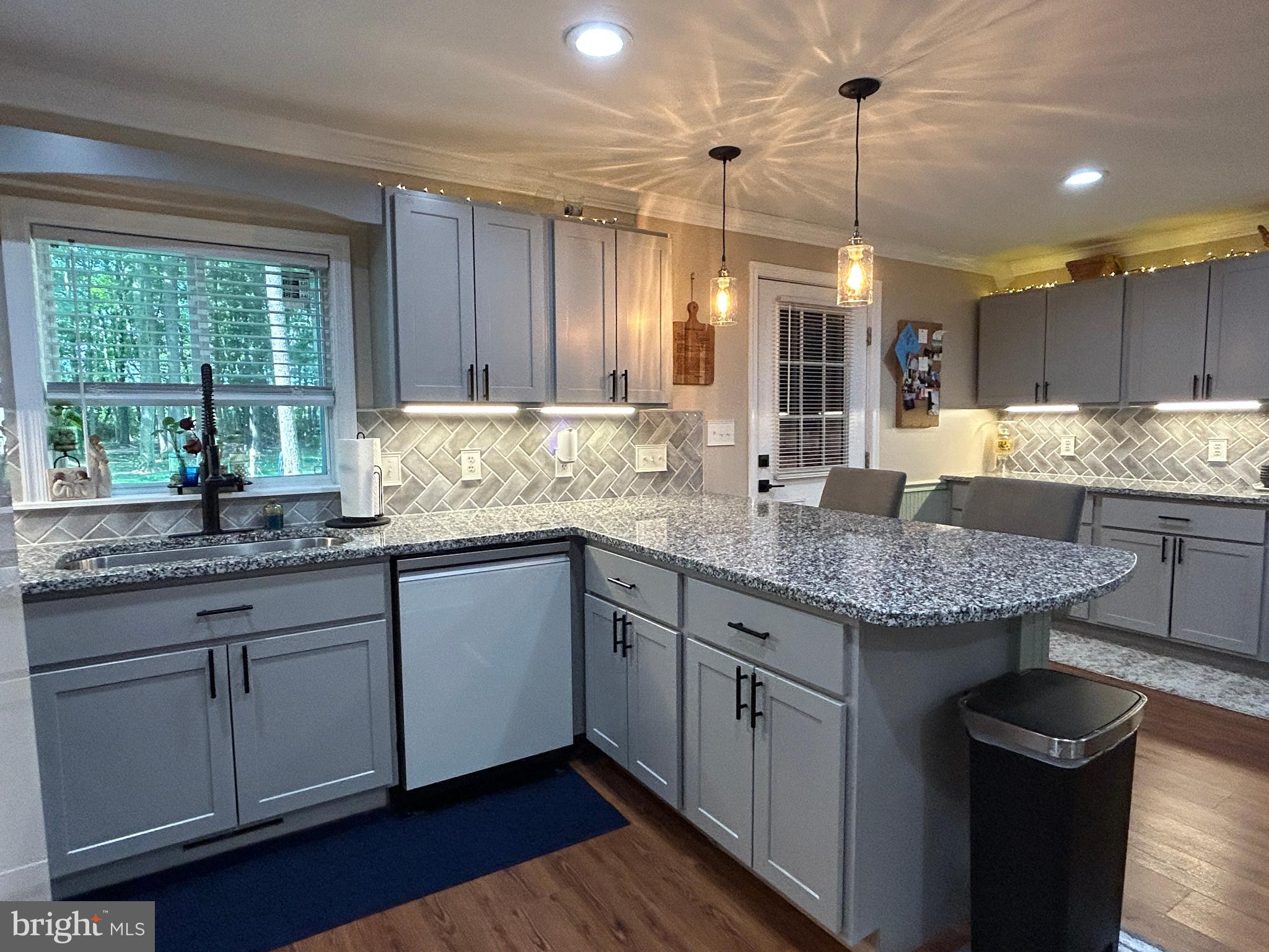 27002 Kaye Road Laurel, DE 19956 - Photo 19 of 64 a kitchen with granite countertop a sink a counter space and wooden cabinets