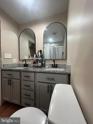 a backyard of a house with wooden fence and large trees