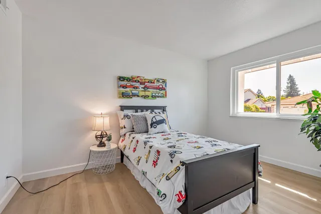 a bedroom with a bed a dresser and a window