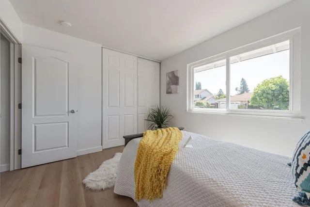 a bedroom with a bed and a potted plant