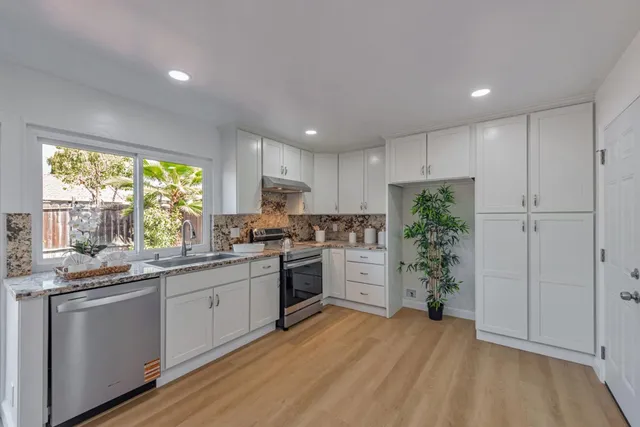 a kitchen with stainless steel appliances granite countertop a refrigerator sink and cabinets